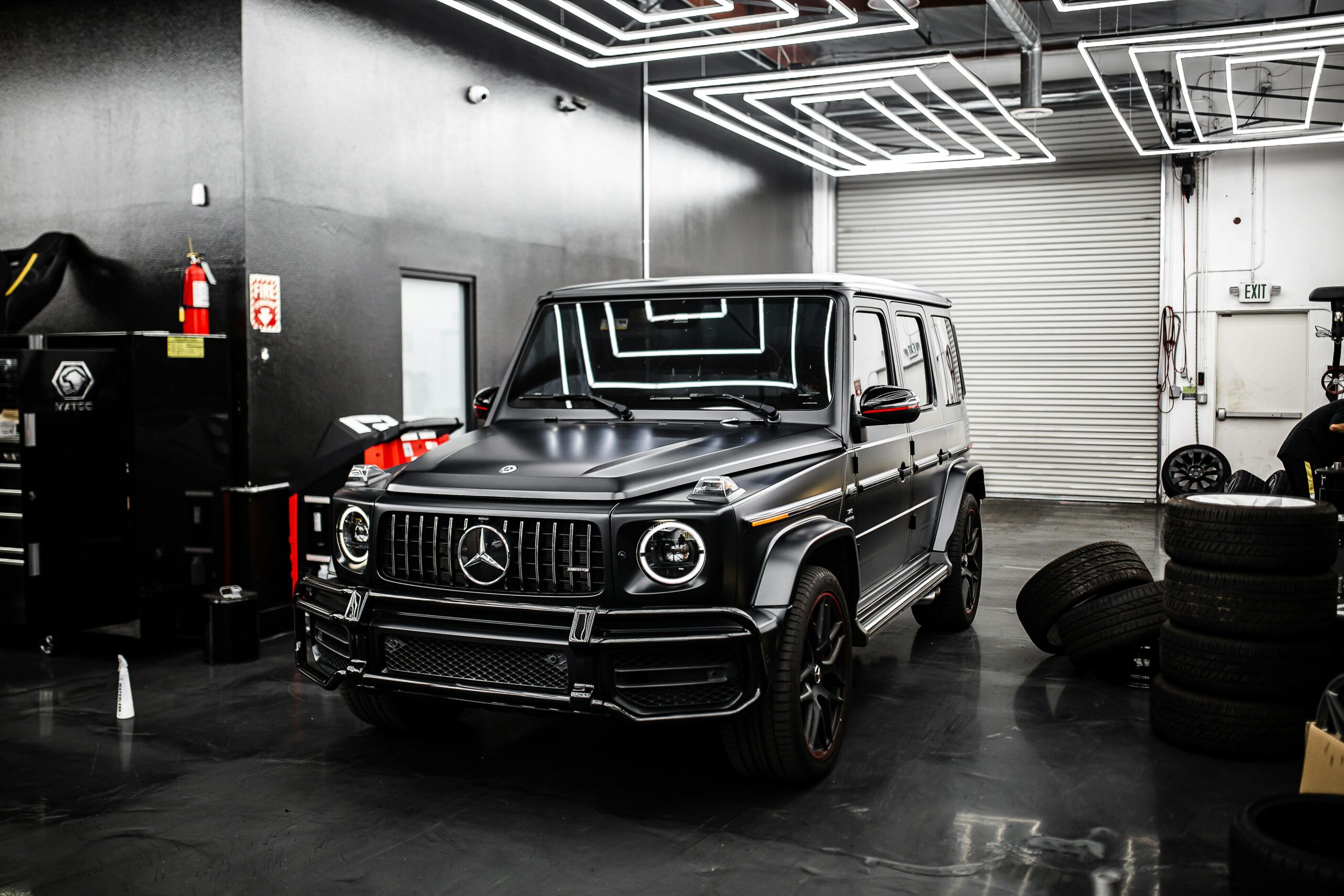 Sleek black SUV parked in a high-end automotive garage. Modern industrial design.