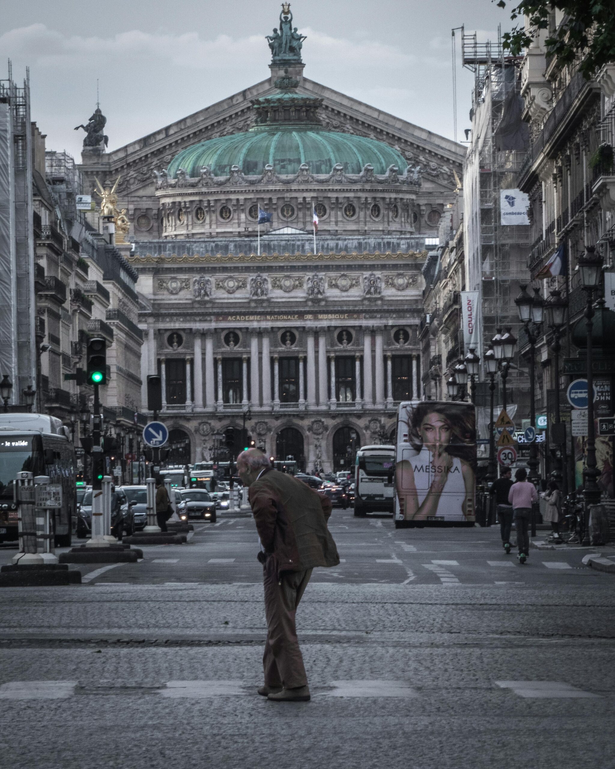 Street view of the bustling environment outside Palais Garnier in Paris during the day.