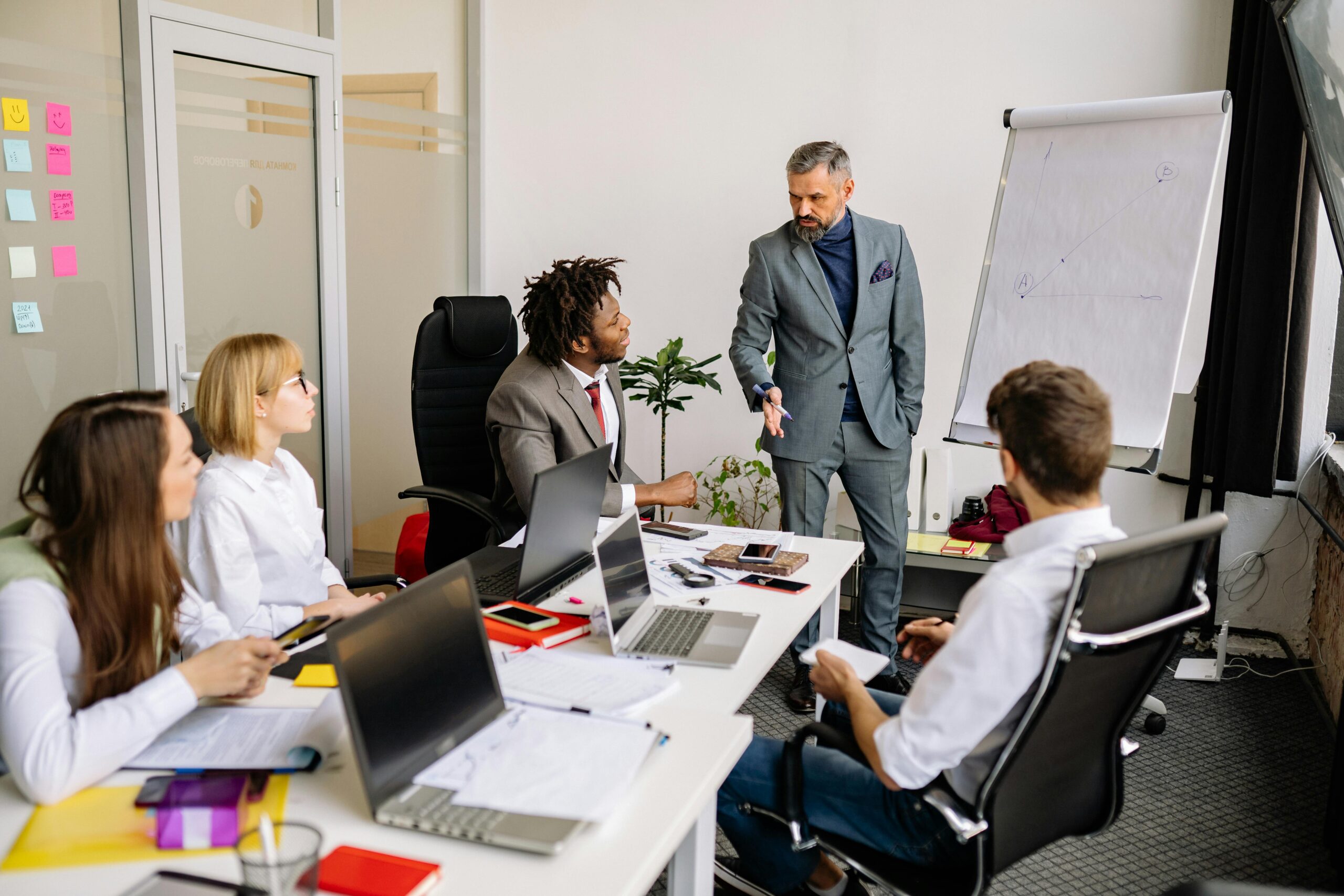 Corporate team in a modern office, engaged in a discussion with diverse colleagues.