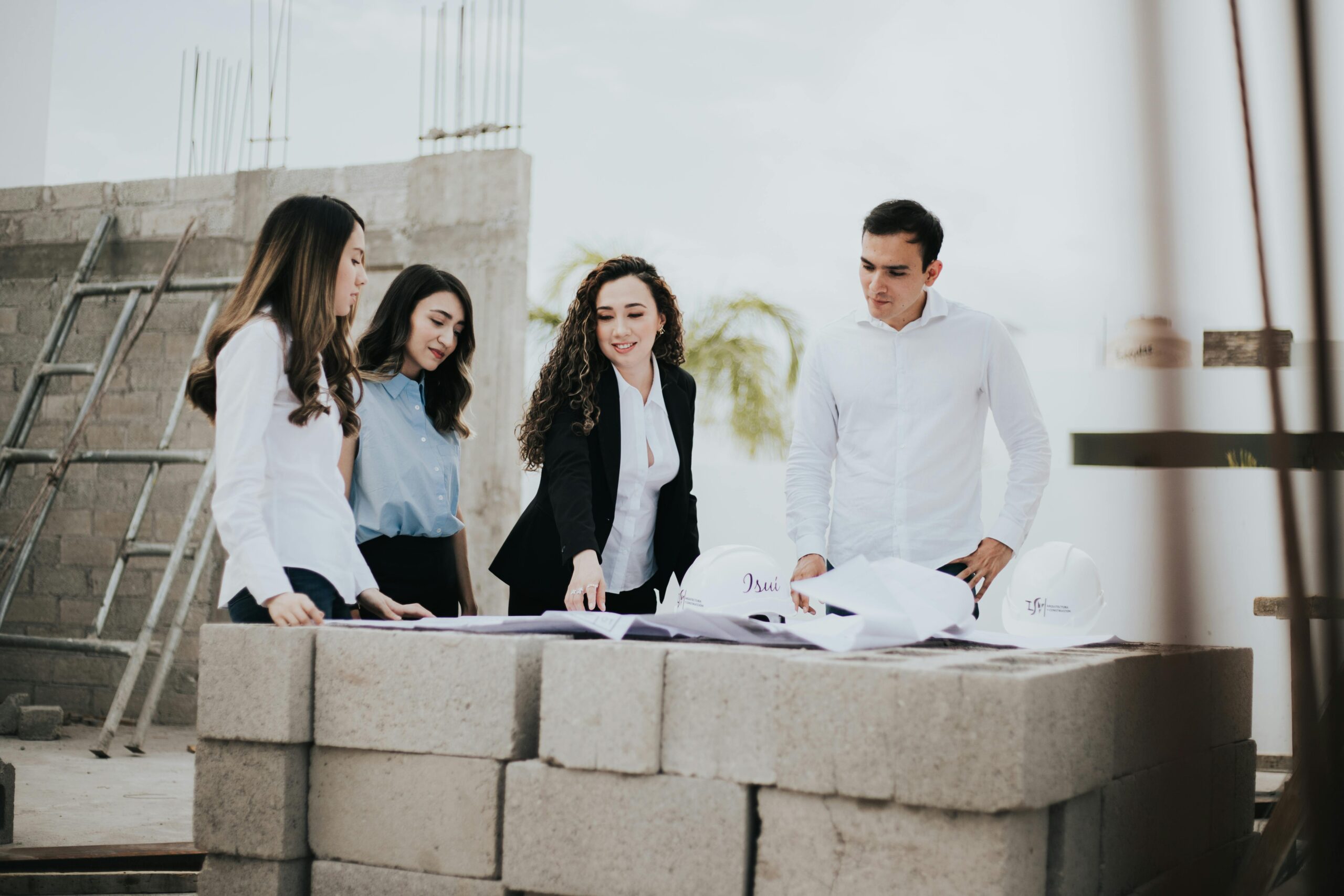 Architectural team reviewing blueprints at a construction site in Los Mochis, Mexico.