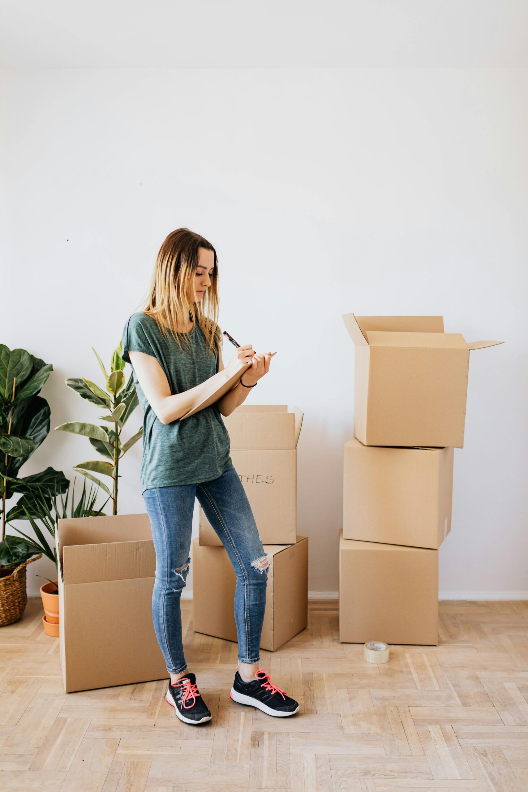 A woman organizes cardboard boxes while moving into a new house.