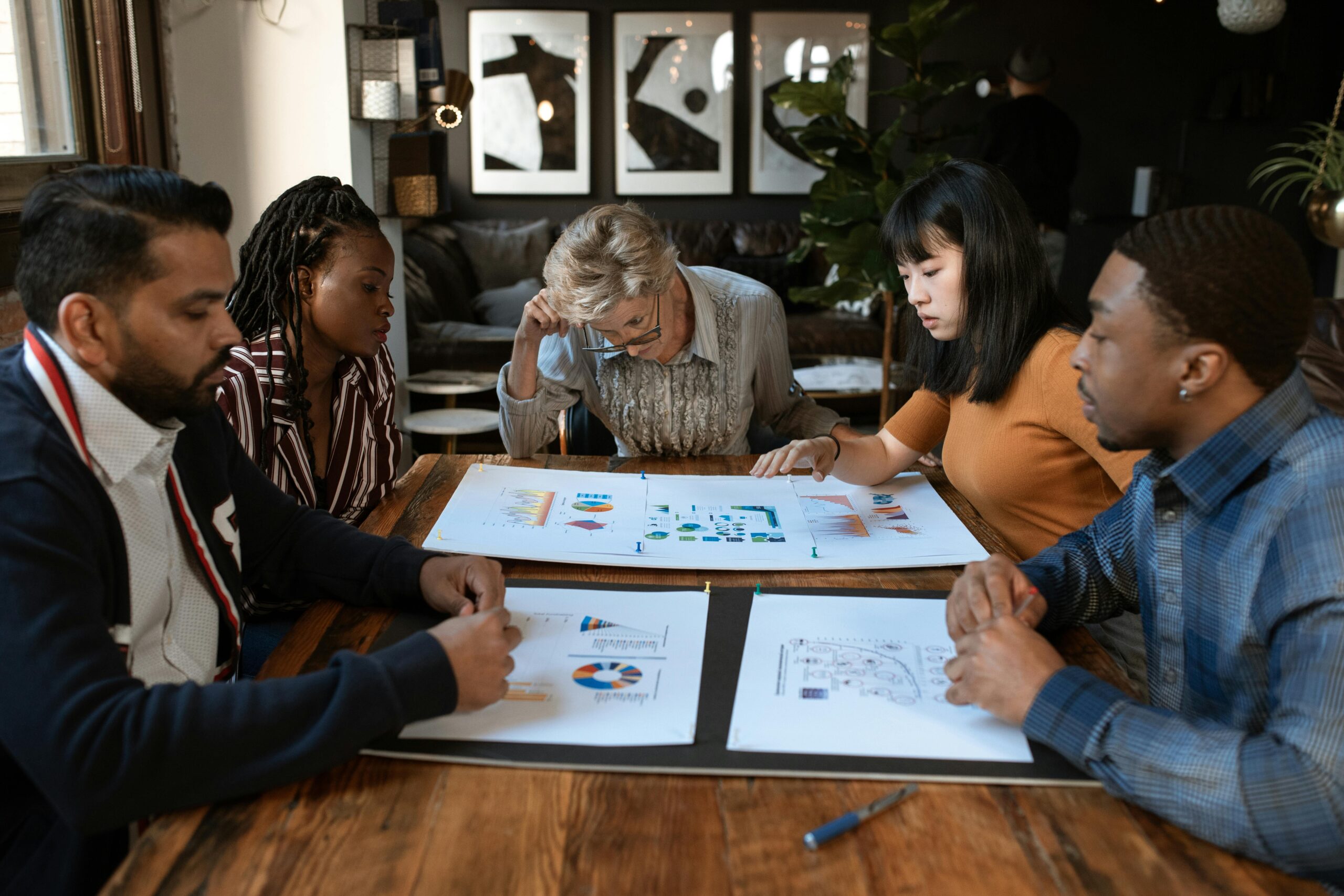 A diverse group of professionals engaged in a collaborative meeting in a modern office setting.