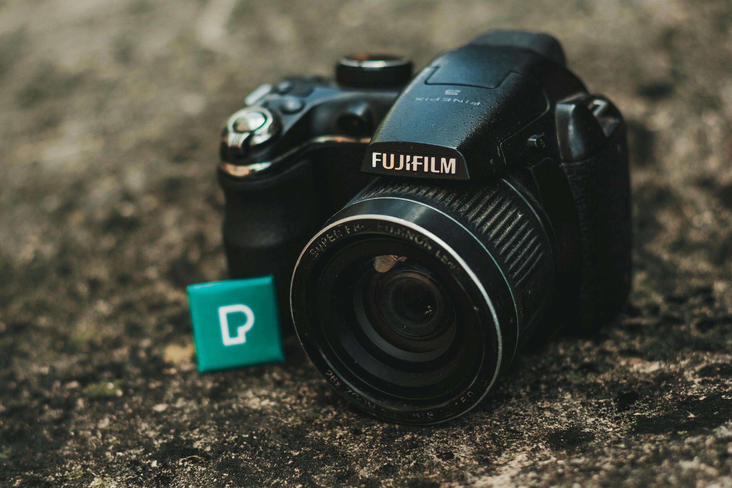 Detailed image of a Fujifilm DSLR camera resting on a textured surface.