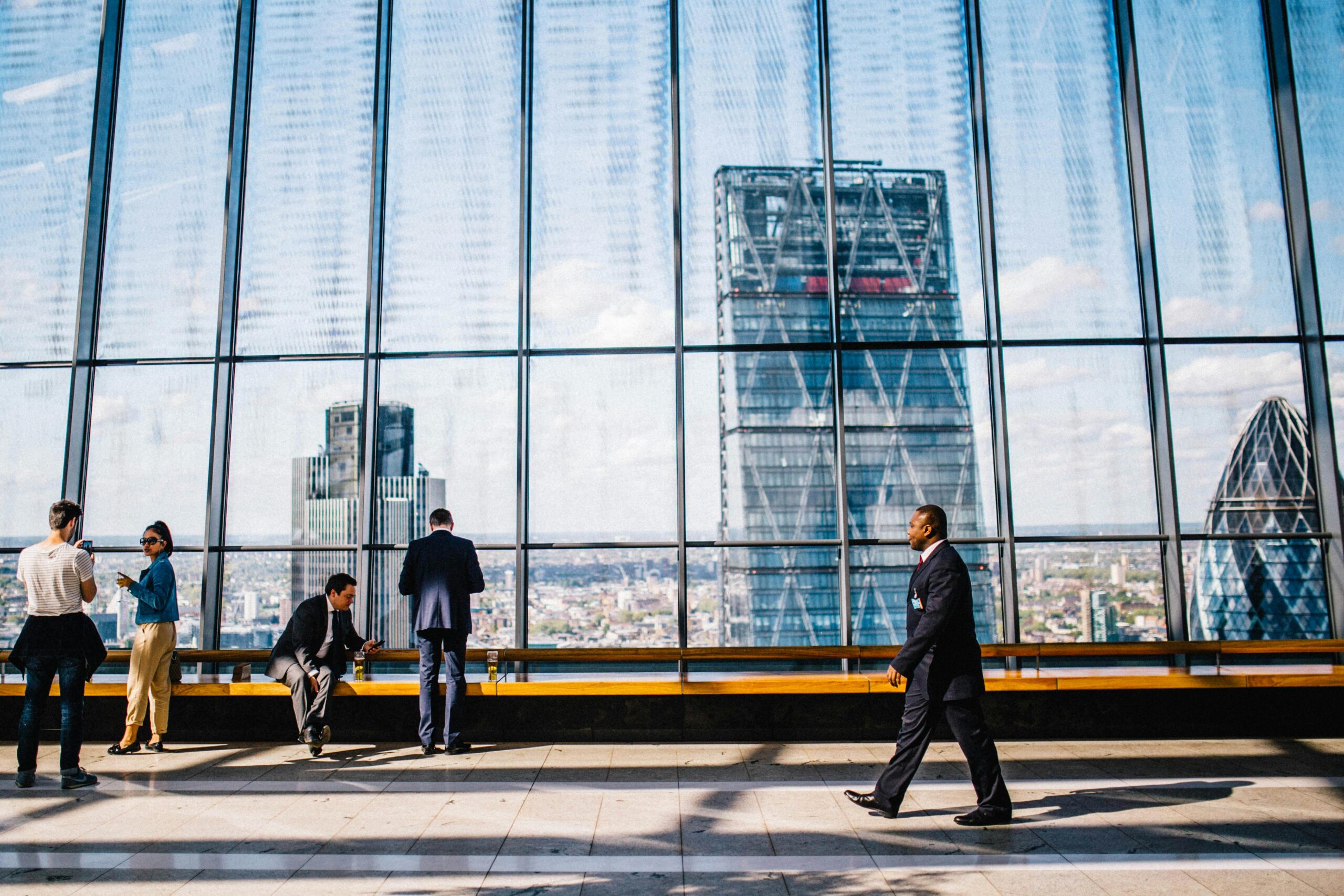 Business professionals in a modern office against a London skyline view.