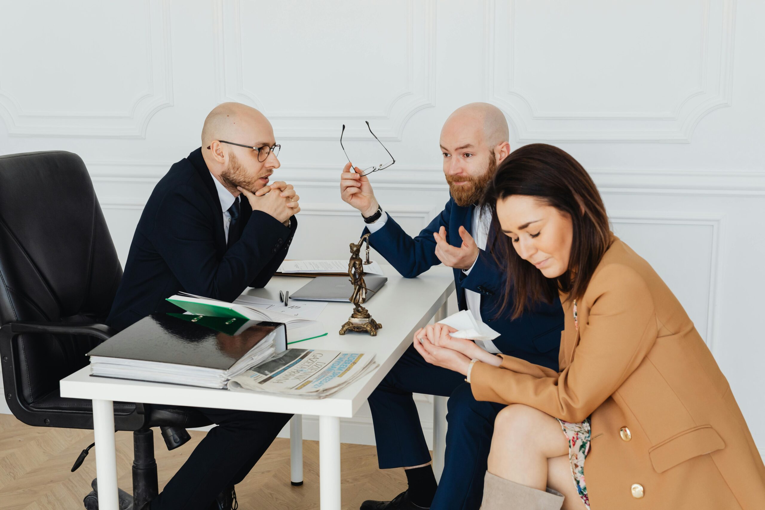 Lawyers mediate a tense meeting with frustrated clients in a law office setting.