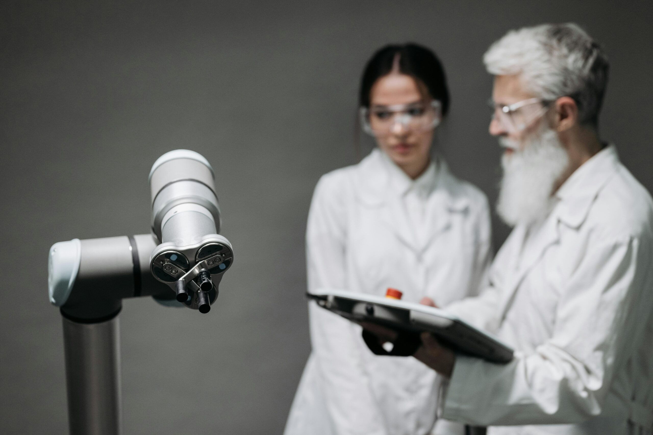 Researchers in lab coats analyze robotic equipment for technological advancement.